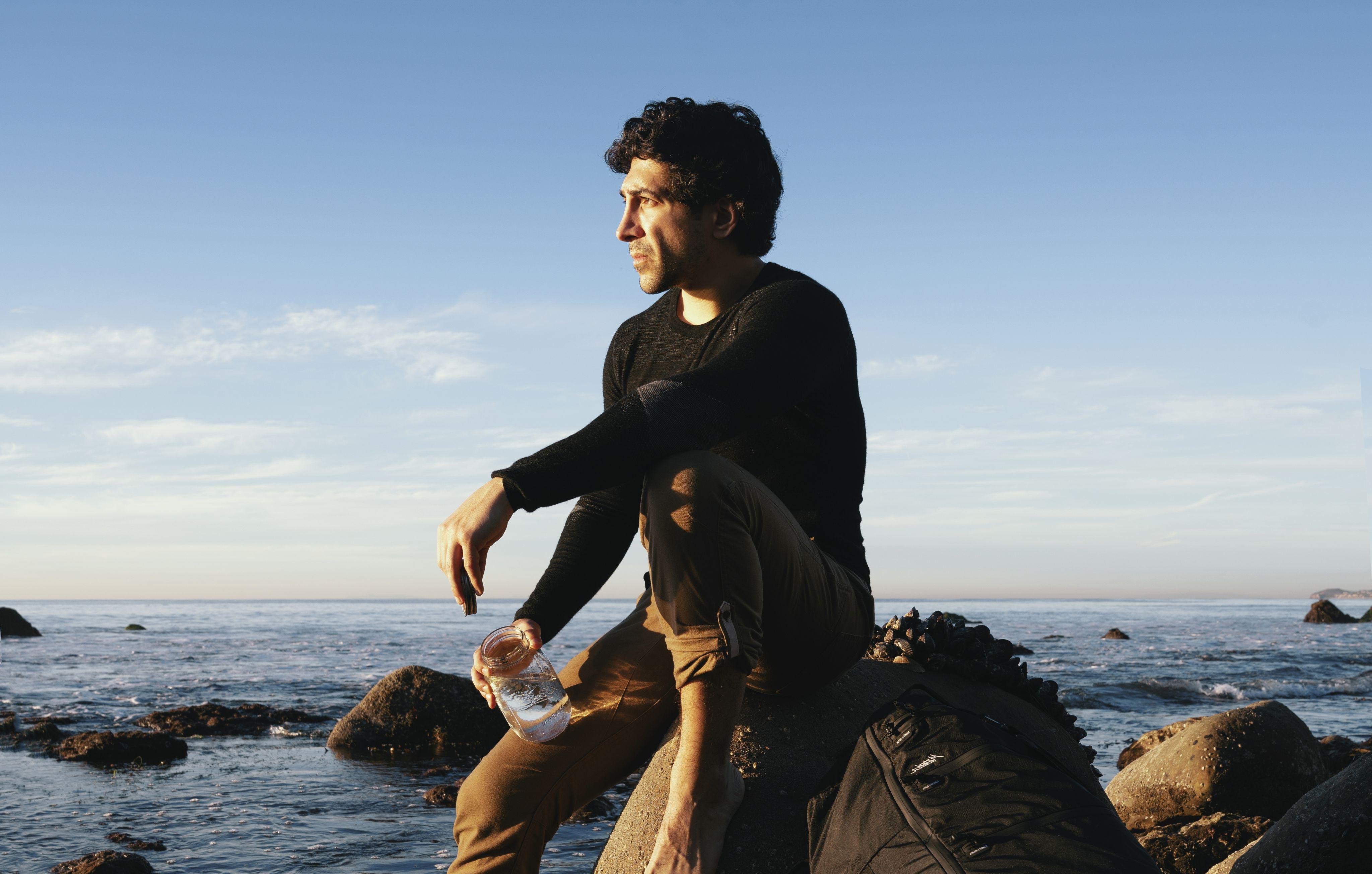 迈克尔·泽沃斯坐在太平洋的一块岩石上