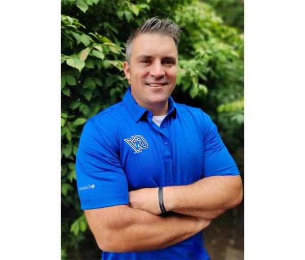 Shane Scherer standing outside in a blue GV golf shirt