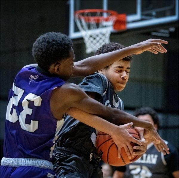 在一场比赛中，两名青年篮球运动员为了抢篮板球而发生冲突.