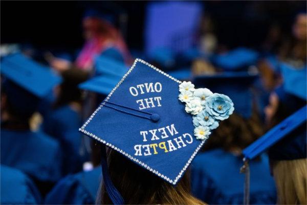 A graduate's cap that reads "Onto the next chapter". 
