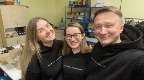 three people wearing black sweatshirts with Technological Dominance printed on front
